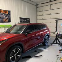 A red SUV with tinted windows by Eco Auto Glass LLC